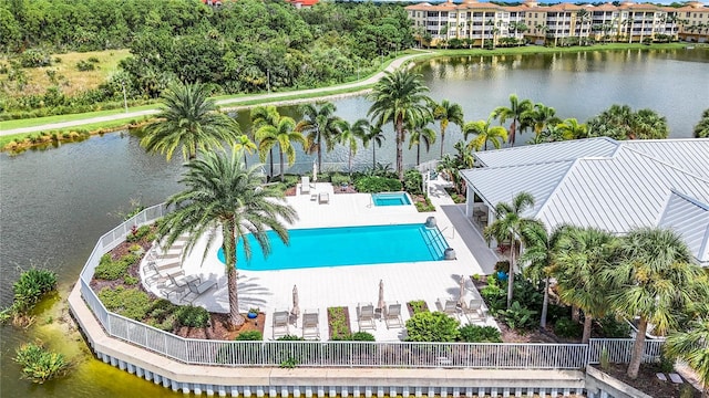 view of swimming pool with a patio area and a water view