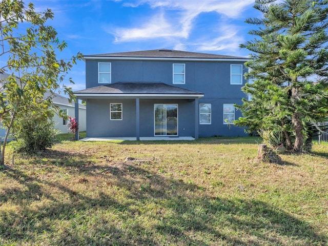 rear view of property with a patio area, a lawn, and stucco siding