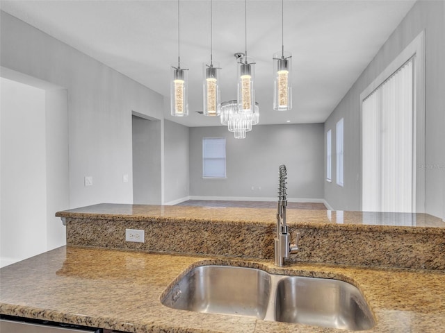 kitchen featuring plenty of natural light, decorative light fixtures, and a sink