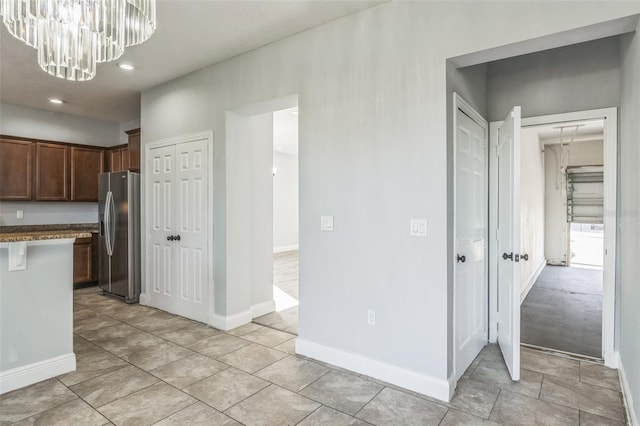 kitchen with a chandelier, stainless steel fridge, decorative light fixtures, and baseboards