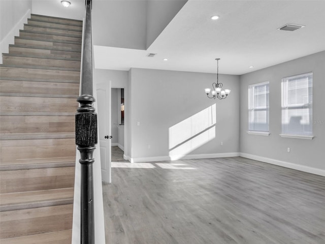 interior space featuring baseboards, stairs, visible vents, and wood finished floors