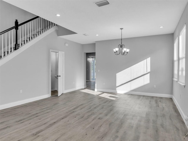 interior space with a chandelier, baseboards, visible vents, and light wood-style floors