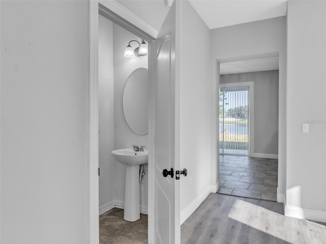 half bathroom with baseboards and wood finished floors