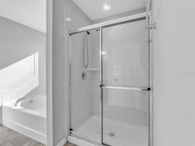 bathroom featuring a stall shower and a bath