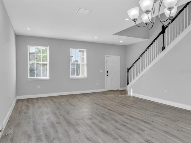 entryway featuring light wood-style flooring, baseboards, and stairs