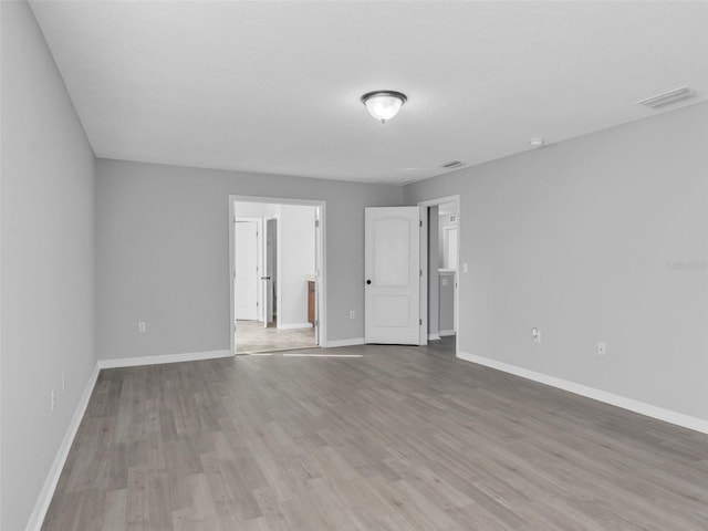 unfurnished bedroom featuring light wood-type flooring, visible vents, and baseboards