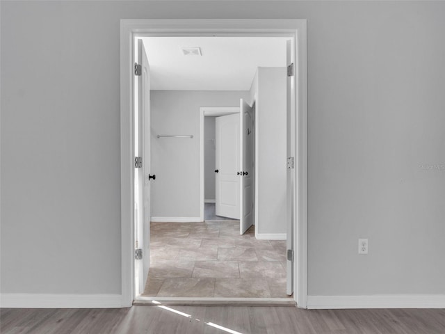 interior space with light wood-type flooring, visible vents, and baseboards