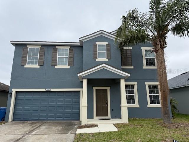 view of front of house with a garage, concrete driveway, and stucco siding