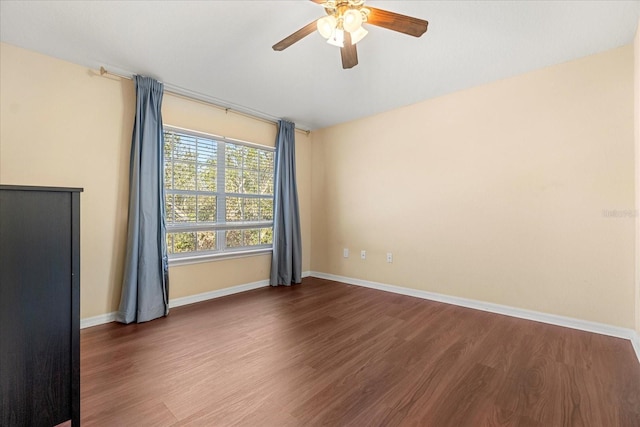 unfurnished room with ceiling fan and dark hardwood / wood-style floors