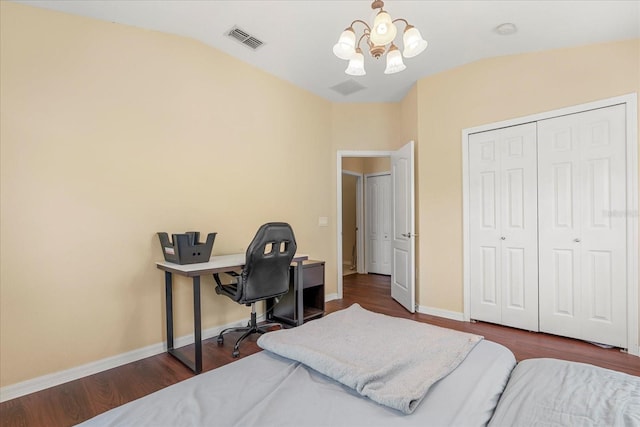 bedroom featuring an inviting chandelier, lofted ceiling, dark hardwood / wood-style floors, and a closet