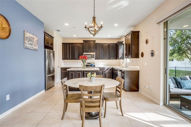 tiled dining room with sink and an inviting chandelier