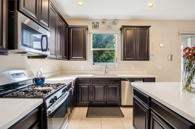 kitchen featuring sink, dark brown cabinets, stainless steel appliances, and light tile patterned floors