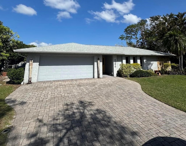 ranch-style home featuring a front lawn and a garage