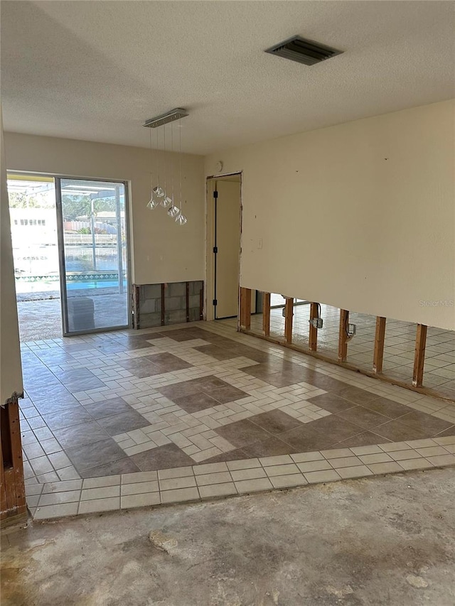 unfurnished room featuring a textured ceiling