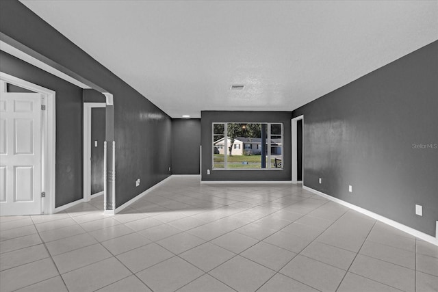 spare room featuring light tile patterned floors and a textured ceiling