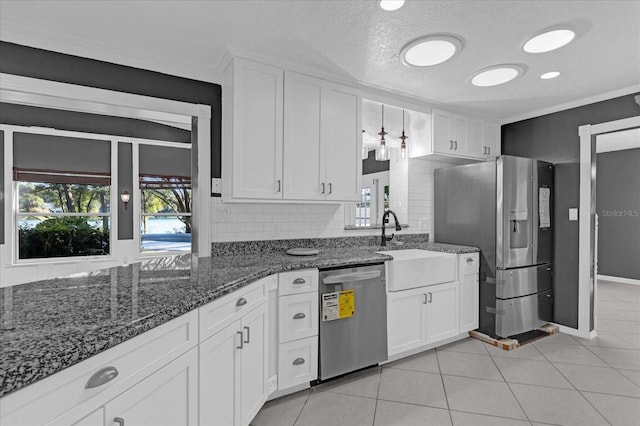 kitchen featuring decorative backsplash, appliances with stainless steel finishes, a textured ceiling, dark stone countertops, and white cabinets