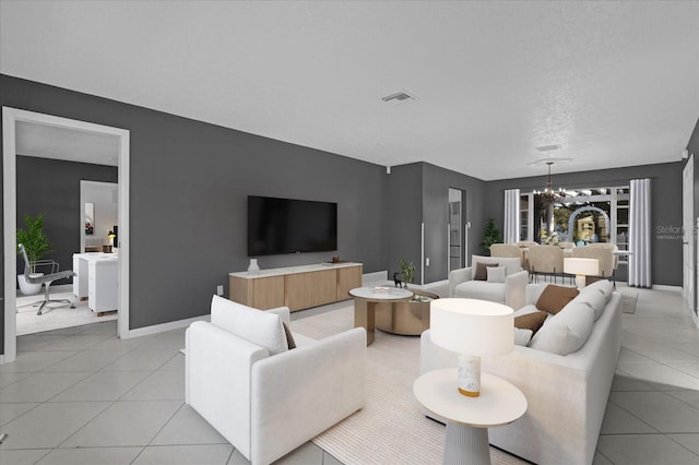 living room with light tile patterned flooring, a textured ceiling, and an inviting chandelier