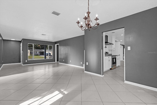 unfurnished room with a notable chandelier and light tile patterned flooring