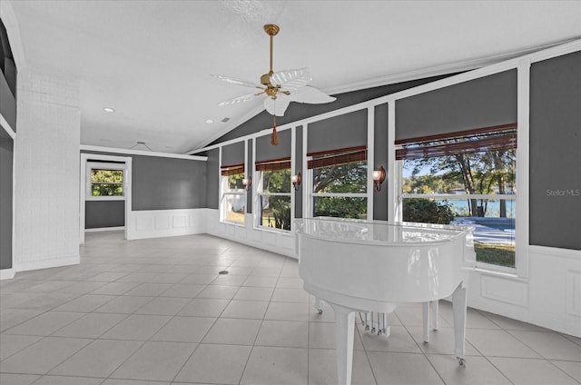 unfurnished dining area featuring ceiling fan, light tile patterned floors, and vaulted ceiling