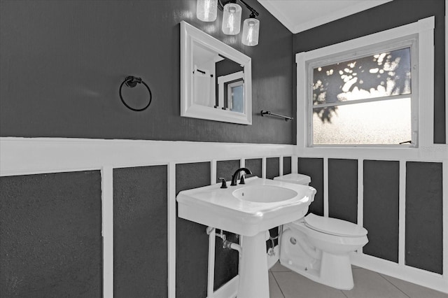 bathroom with tile patterned floors, toilet, and crown molding