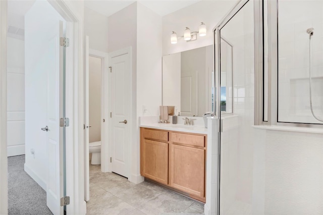 bathroom with toilet, tiled shower, and vanity