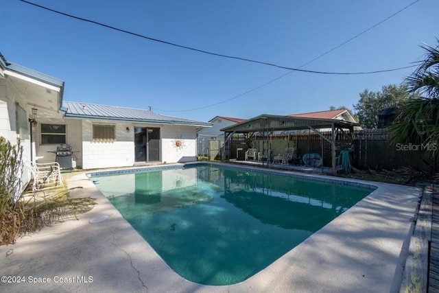 view of swimming pool featuring a patio area and a grill