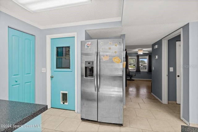 kitchen featuring stainless steel fridge, ceiling fan, a textured ceiling, and light tile patterned floors