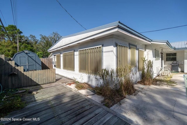 view of property exterior featuring a shed and a patio area