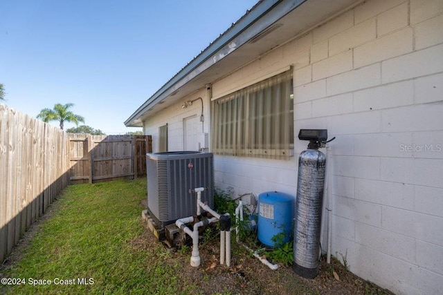 view of home's exterior with cooling unit and a lawn