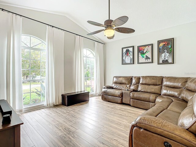 living room with ceiling fan, light hardwood / wood-style flooring, and lofted ceiling