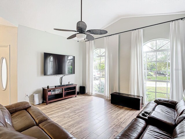 living room with ceiling fan, a wealth of natural light, vaulted ceiling, and light hardwood / wood-style floors