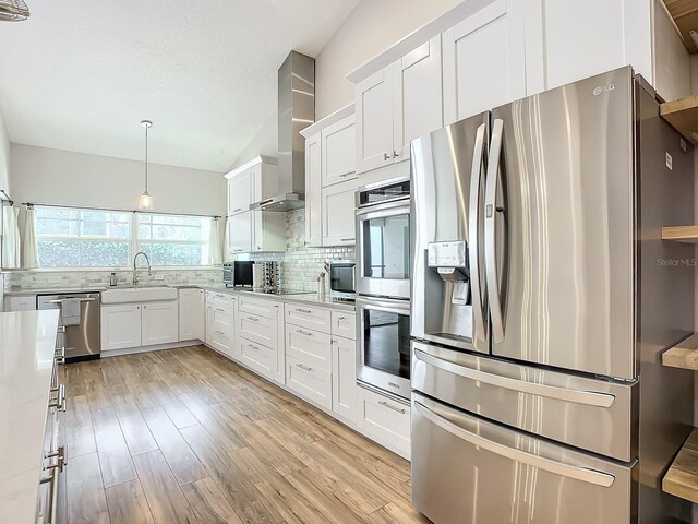 kitchen featuring stainless steel appliances, light hardwood / wood-style floors, white cabinets, and sink