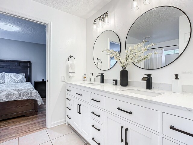 bathroom with wood-type flooring, a textured ceiling, and vanity