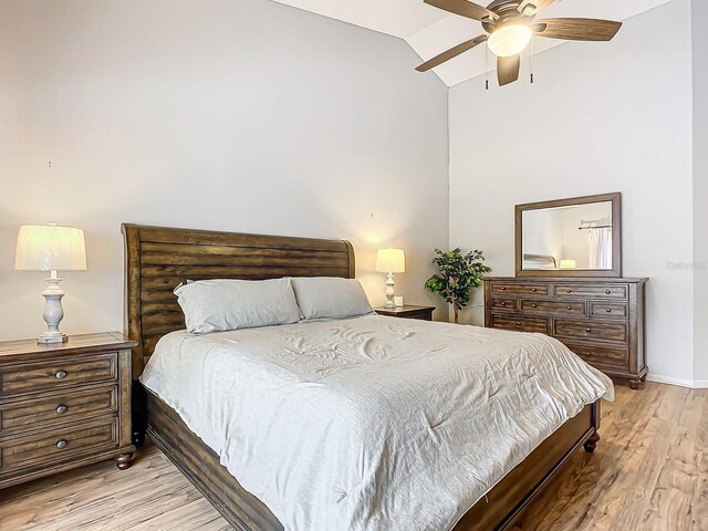 bedroom featuring light hardwood / wood-style floors, lofted ceiling, and ceiling fan