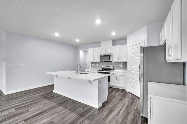 kitchen featuring white cabinetry, sink, backsplash, an island with sink, and appliances with stainless steel finishes