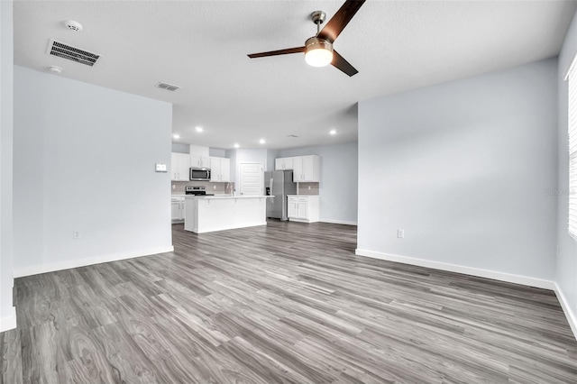 unfurnished living room featuring ceiling fan and light wood-type flooring