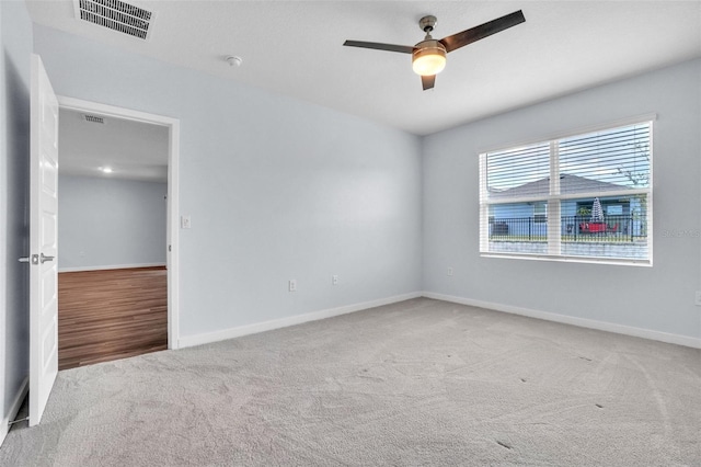 carpeted spare room featuring ceiling fan