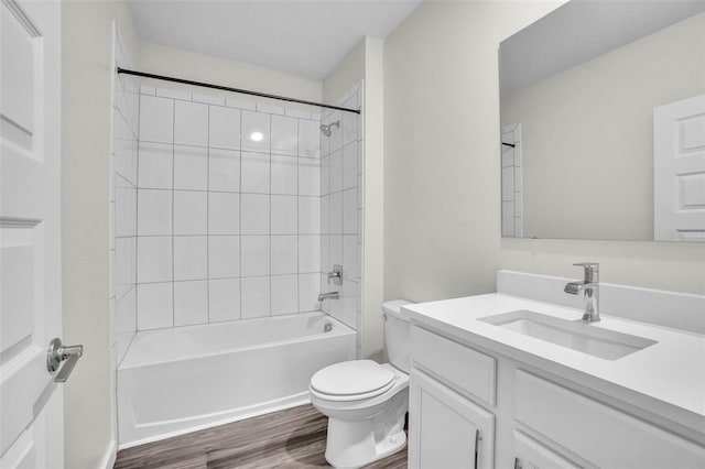 full bathroom featuring toilet, vanity, tiled shower / bath combo, and hardwood / wood-style flooring