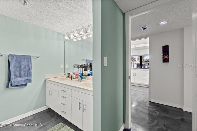 bathroom featuring vanity, concrete flooring, and a textured ceiling