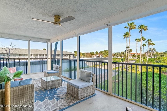 sunroom / solarium with a water view and ceiling fan