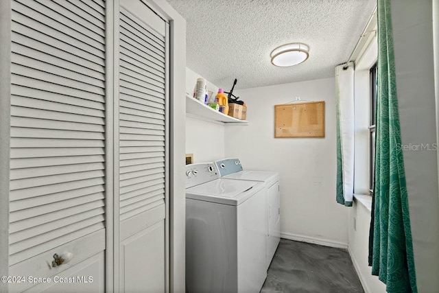 laundry room with a textured ceiling and washer and clothes dryer