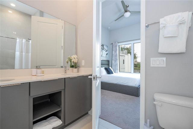 bathroom with toilet, walk in shower, vanity, and ceiling fan