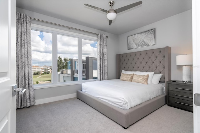 carpeted bedroom featuring ceiling fan and multiple windows