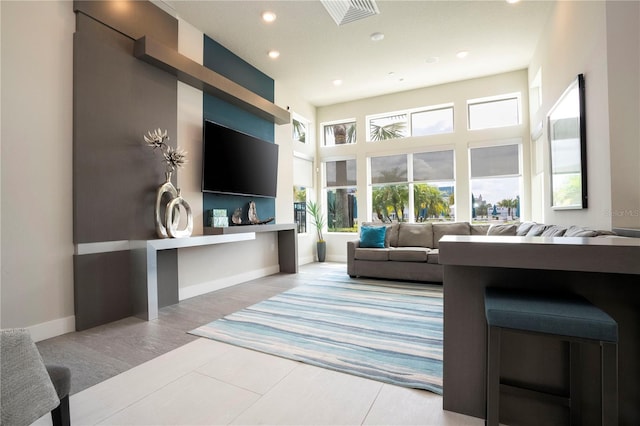 living room with tile patterned floors and a high ceiling