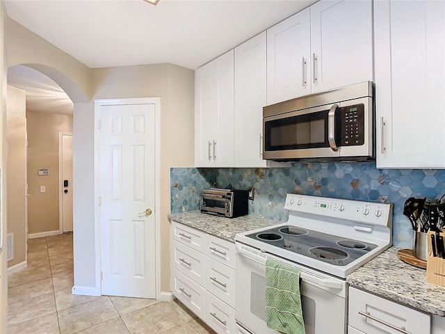 kitchen with white cabinetry, tasteful backsplash, light stone counters, and white range with electric cooktop