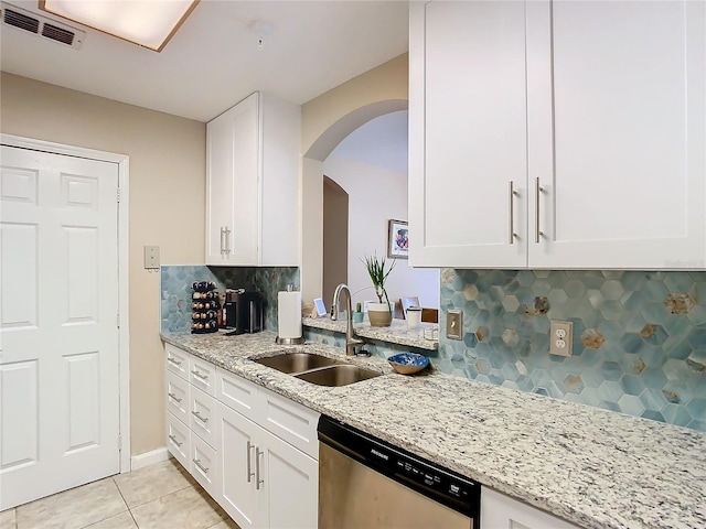 kitchen with tasteful backsplash, sink, dishwasher, white cabinetry, and light stone counters