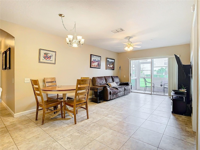 tiled dining space featuring ceiling fan with notable chandelier