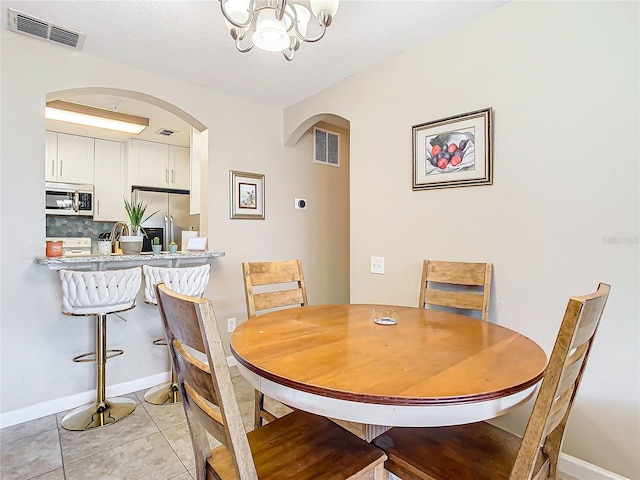 dining space featuring a notable chandelier and light tile patterned floors