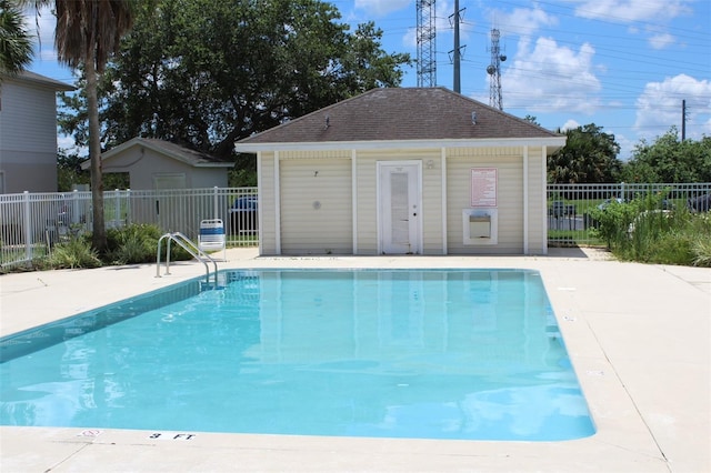 view of pool with a patio and an outbuilding