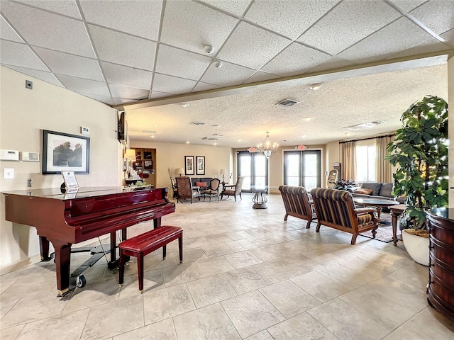 misc room featuring a drop ceiling and a notable chandelier